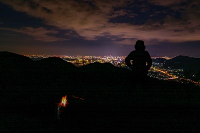 夜间站在山顶上的人的剪影